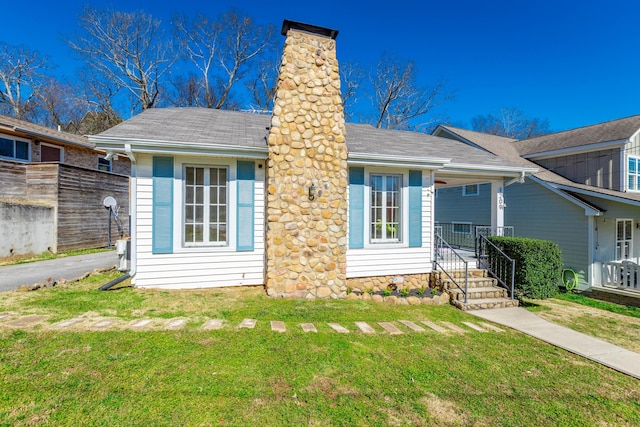 view of front of home featuring a chimney and a front lawn