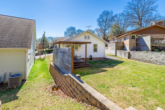 rear view of property featuring a lawn, cooling unit, a pergola, and fence