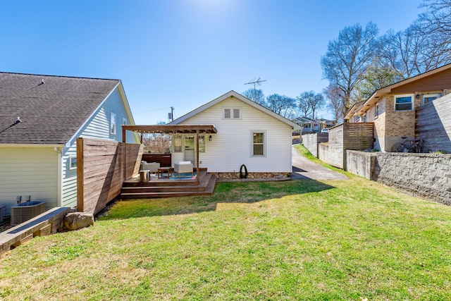 back of property featuring a deck, central AC unit, a lawn, and fence