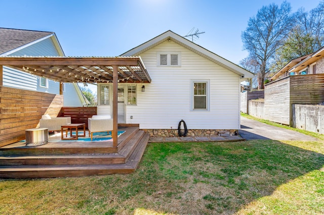 back of house featuring a deck, a lawn, and fence