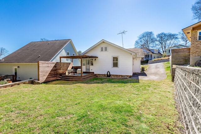 back of property featuring a yard, fence, and a wooden deck