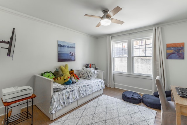 bedroom featuring ornamental molding, a ceiling fan, baseboards, and wood finished floors