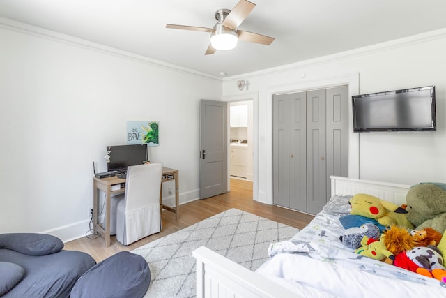 bedroom with washer / dryer, baseboards, light wood-style floors, and crown molding