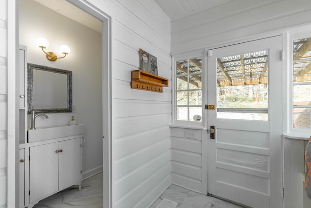 doorway featuring marble finish floor and a sink