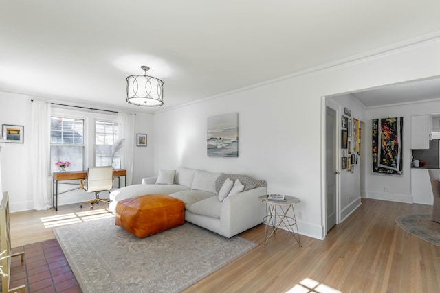 living room with ornamental molding, baseboards, and wood finished floors