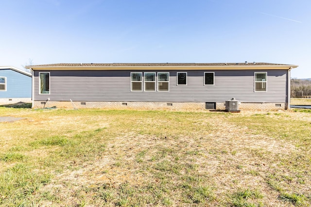 rear view of property featuring crawl space, a lawn, and cooling unit