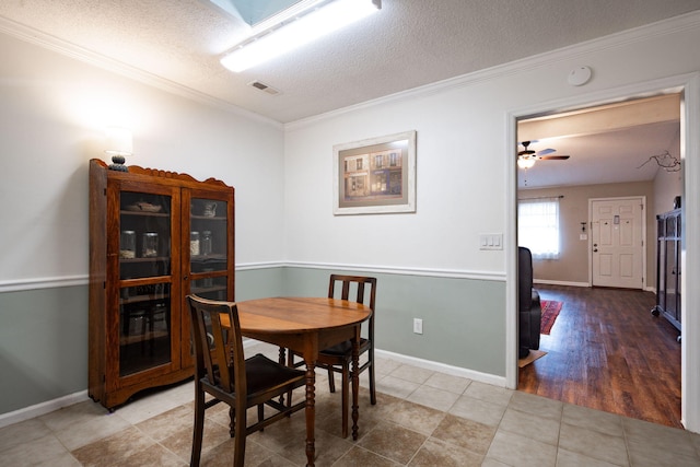 dining space with visible vents, crown molding, a textured ceiling, and baseboards