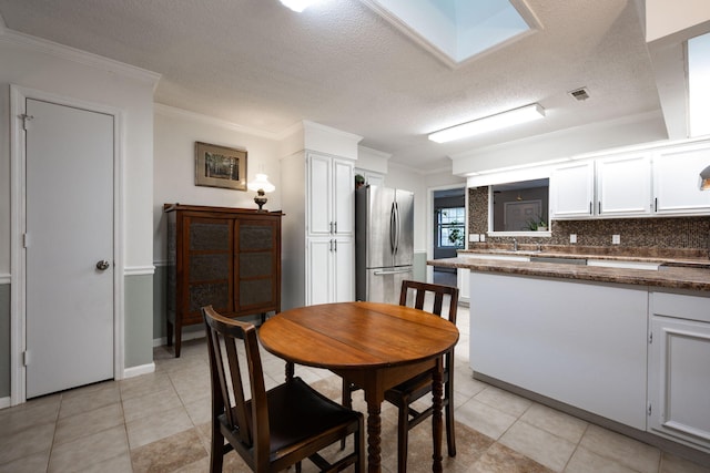 dining space featuring visible vents, crown molding, a textured ceiling, and light tile patterned floors