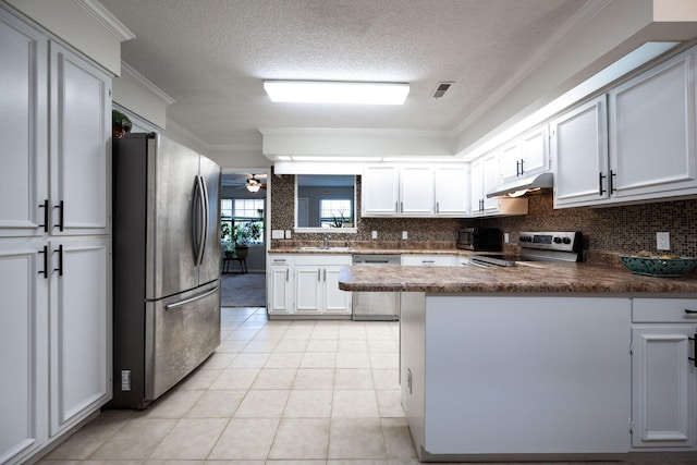 kitchen with visible vents, appliances with stainless steel finishes, ornamental molding, a peninsula, and under cabinet range hood