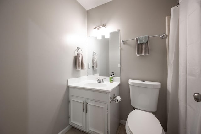 bathroom featuring vanity, toilet, and baseboards