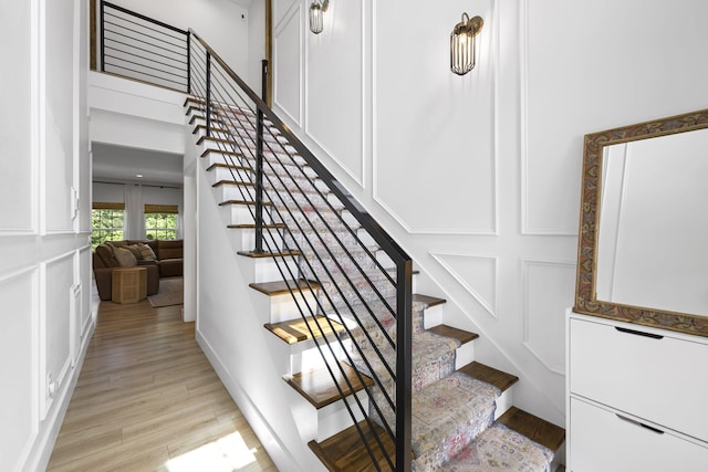 stairs with a high ceiling and hardwood / wood-style floors