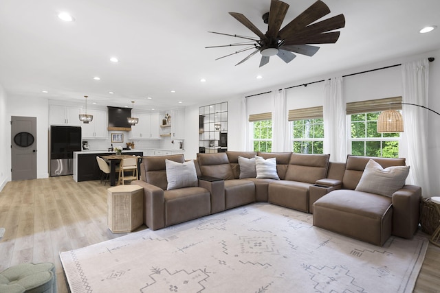 living room with ceiling fan and light hardwood / wood-style floors