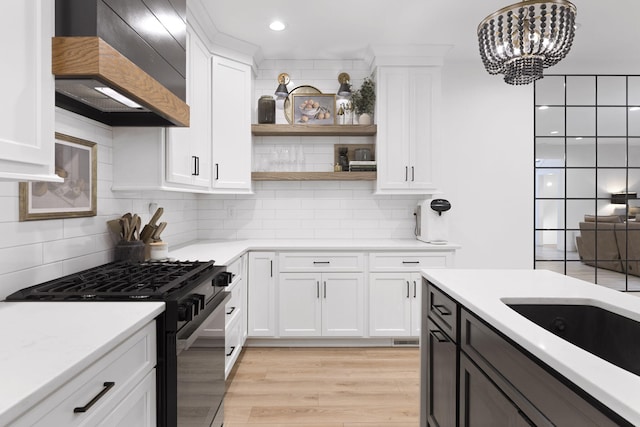 kitchen with white cabinets, black range with gas cooktop, and custom range hood