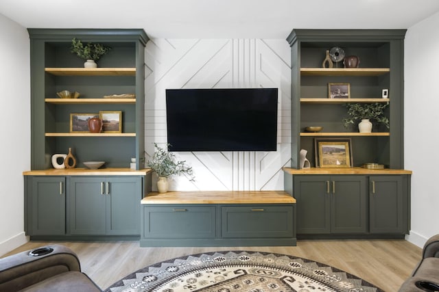 living room with light wood-type flooring and built in shelves