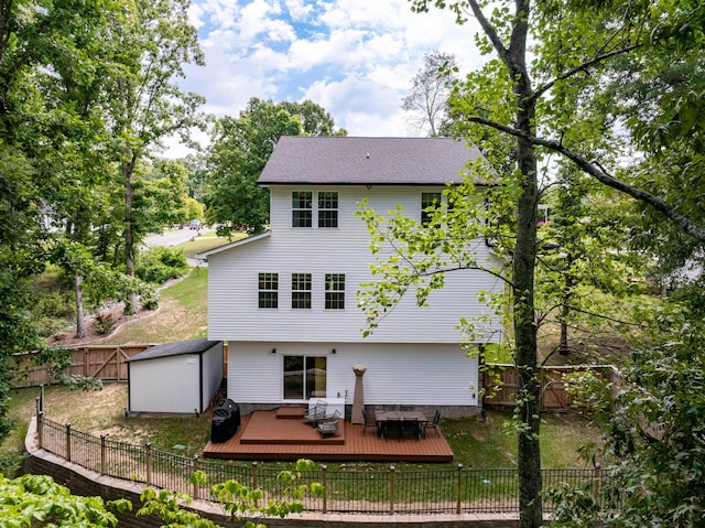 back of property with a deck and a shed