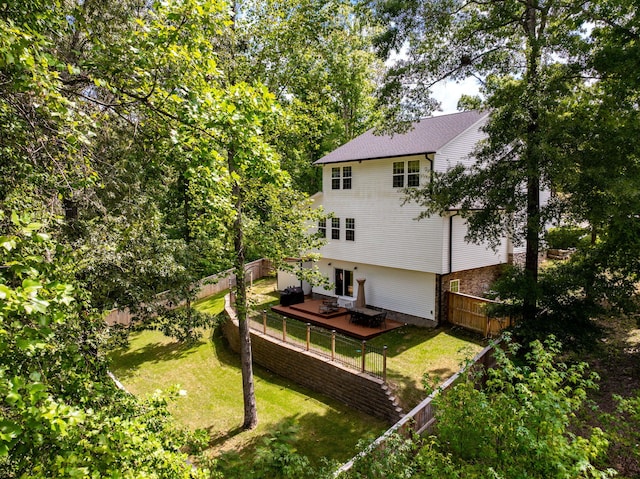 back of property with a deck and a lawn