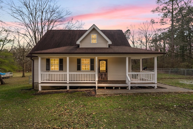 farmhouse inspired home with a porch and a front yard