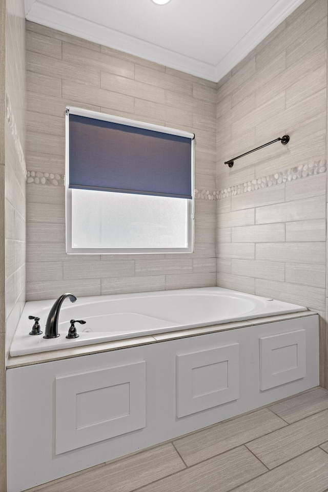 full bath with a garden tub, tile walls, and crown molding