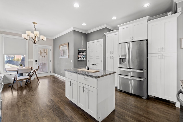 kitchen featuring stainless steel fridge, dark wood finished floors, dark stone countertops, and white cabinetry