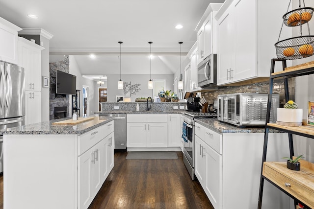 kitchen with stainless steel appliances, pendant lighting, and white cabinetry