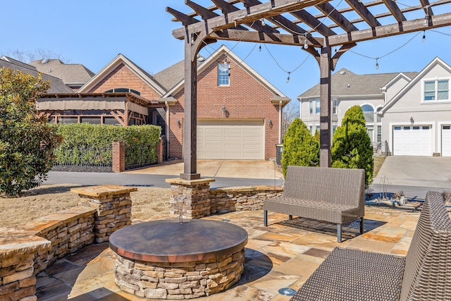 view of patio with a garage, an outdoor fire pit, and a pergola