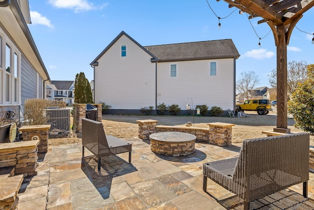 view of patio / terrace featuring a fire pit, central AC, a residential view, and a pergola