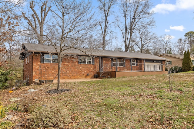 ranch-style house with brick siding, a garage, and a front yard