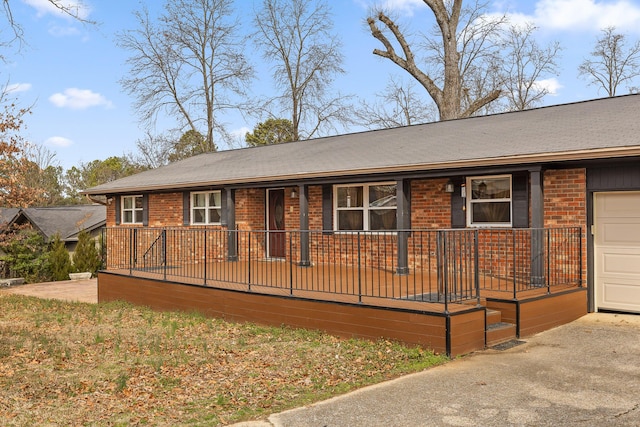 single story home with covered porch, brick siding, and driveway