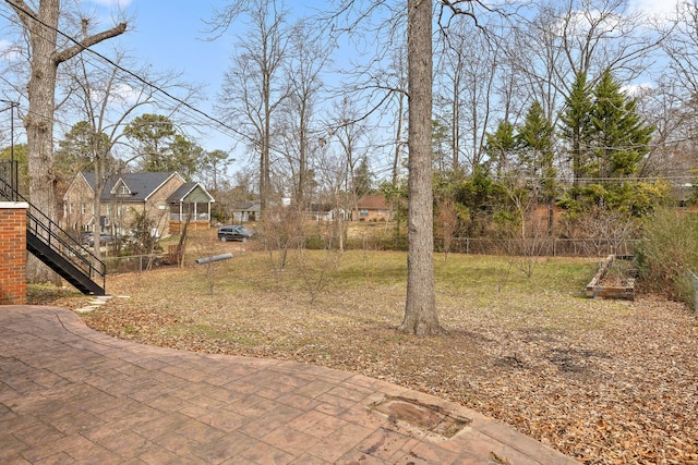 view of yard with stairs and fence