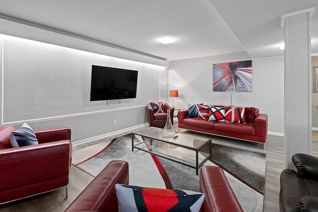living room with wood finished floors, baseboards, and a textured ceiling