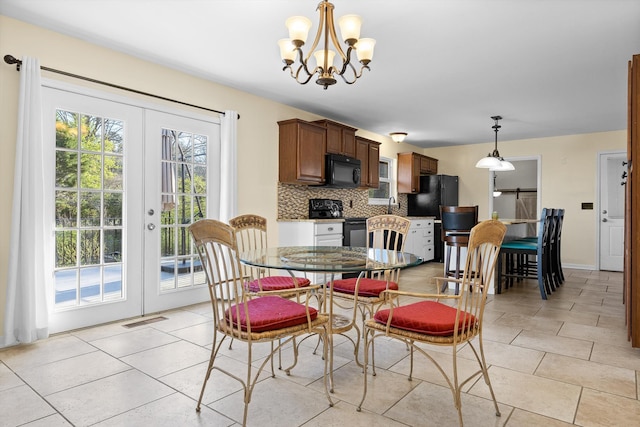 dining space with visible vents, french doors, an inviting chandelier, and light tile patterned floors