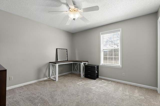 office space with visible vents, baseboards, carpet, a textured ceiling, and a ceiling fan