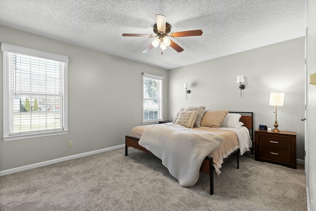 bedroom with a textured ceiling, light colored carpet, baseboards, and ceiling fan