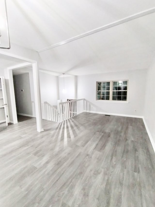 spare room with lofted ceiling and light hardwood / wood-style floors