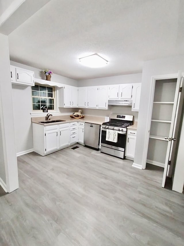 kitchen featuring white cabinetry, sink, stainless steel appliances, and light hardwood / wood-style floors