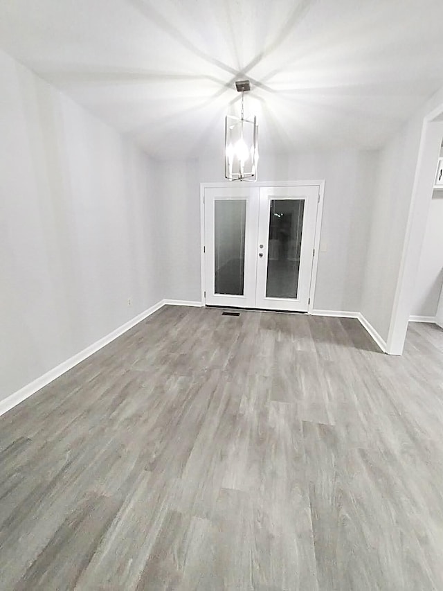 empty room with a chandelier and hardwood / wood-style flooring