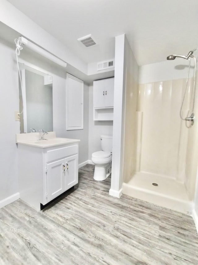 bathroom with walk in shower, toilet, hardwood / wood-style floors, and vanity