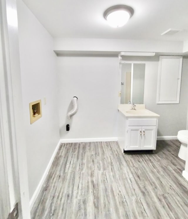 clothes washing area featuring hookup for a washing machine, sink, and light hardwood / wood-style flooring