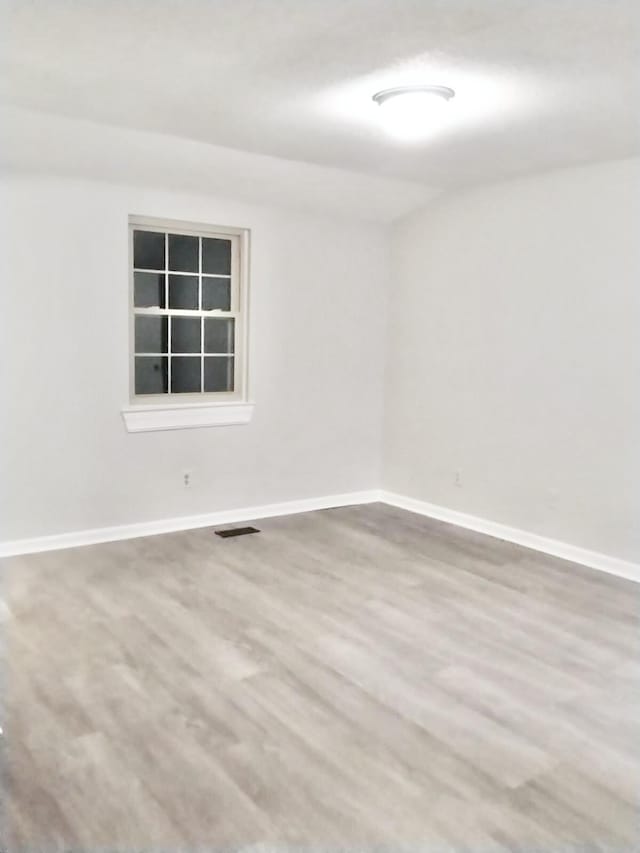 unfurnished room with hardwood / wood-style flooring
