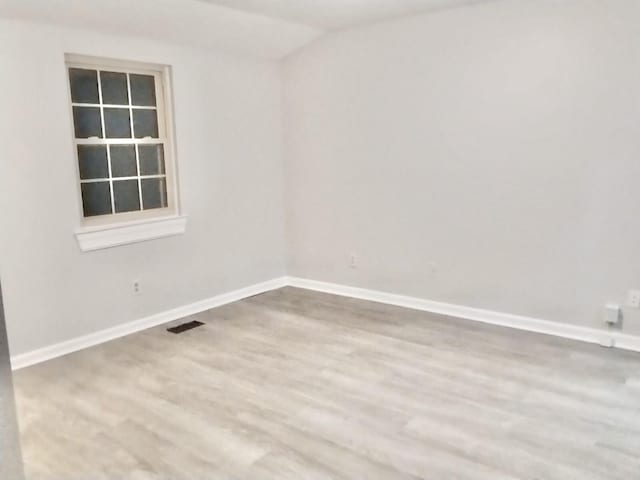 unfurnished room with lofted ceiling and wood-type flooring