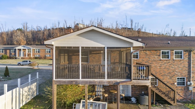 rear view of property featuring central AC and a sunroom