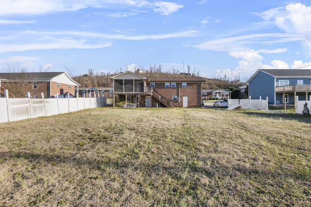 back of house featuring a yard and a sunroom