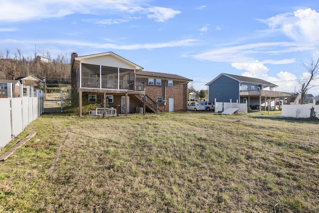 back of property featuring a lawn and a sunroom