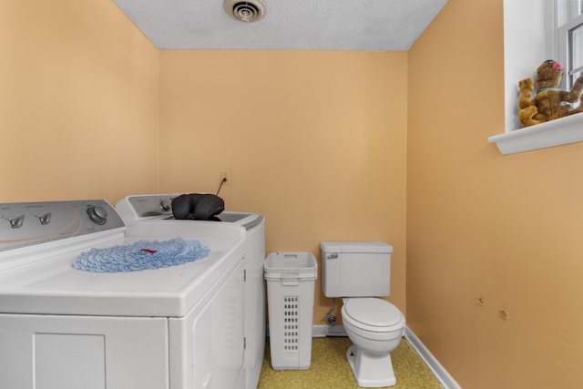 washroom with separate washer and dryer and a textured ceiling