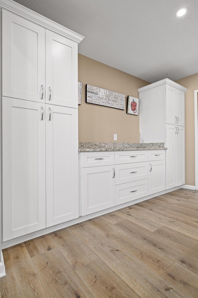 interior space featuring a textured ceiling and light wood finished floors