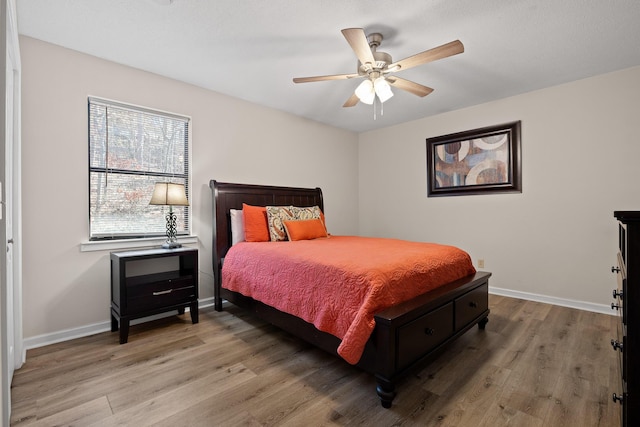 bedroom with light wood finished floors, ceiling fan, and baseboards