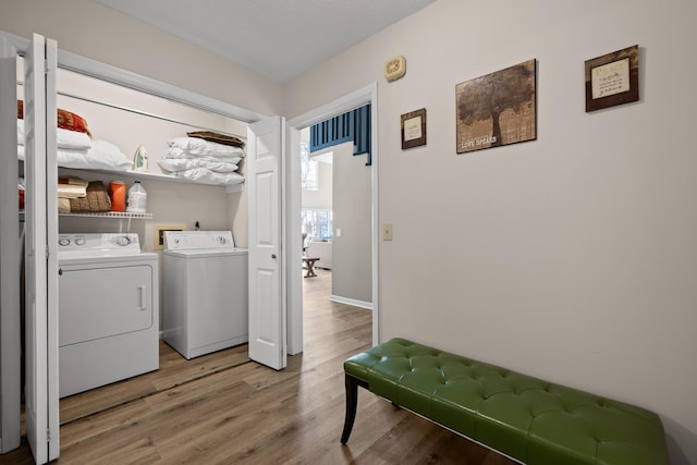 laundry area with laundry area, light wood-style floors, and washing machine and clothes dryer