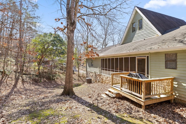 view of yard with a sunroom, central AC, and a wooden deck