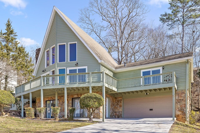 view of front of home with stone siding, concrete driveway, an attached garage, and a balcony