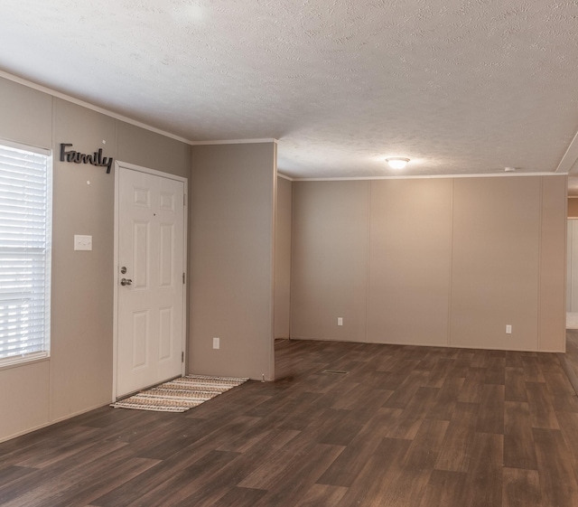 interior space with ornamental molding, dark wood finished floors, and a textured ceiling